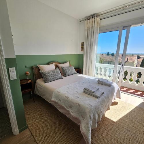 a bedroom with a large bed with a balcony at Villa Marguerite in Hyères