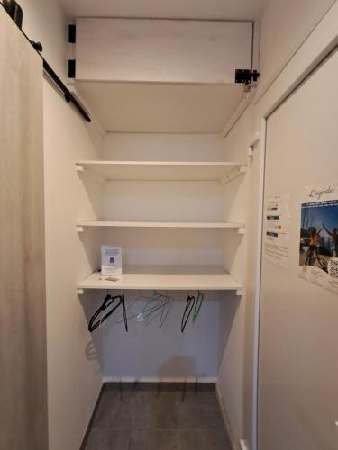 a walk in closet with white shelves at Locmeze in Mèze