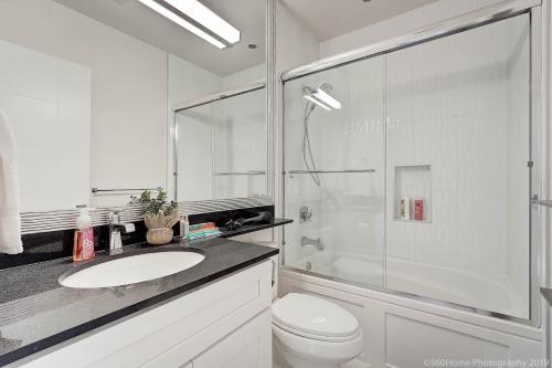 a white bathroom with a sink and a shower at Quiet Suites Up to 8 Guests Near DTVan Monthly Option in West Vancouver