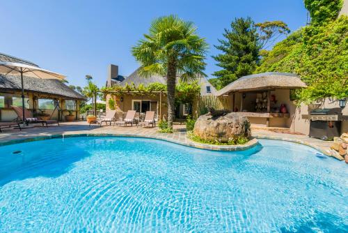 a large swimming pool in front of a house at Ikhaya Safari Lodge in Cape Town