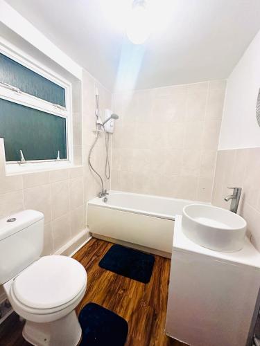 a white bathroom with a toilet and a sink at Reading Central Haven in Reading