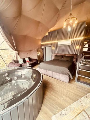 a room with a bed and a tub in a tent at ByDamla Bungalov in Sapanca