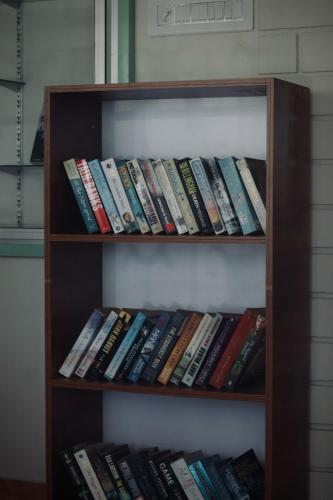 a book shelf filled with lots of books at Calathea home varkala beach in Varkala