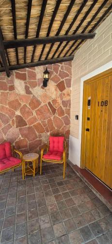 two red chairs and a table on a patio at Sandy Shores Cabaña 10 in La Paz