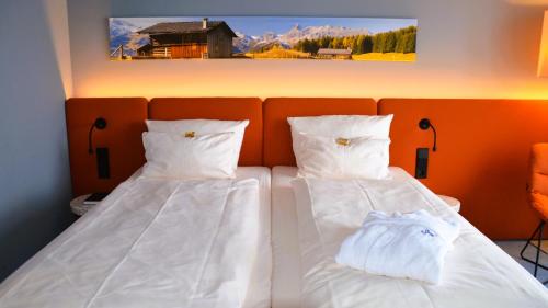 two beds with white sheets and pillows in a room at Stay2Munich Hotel & Serviced Apartments in Brunnthal