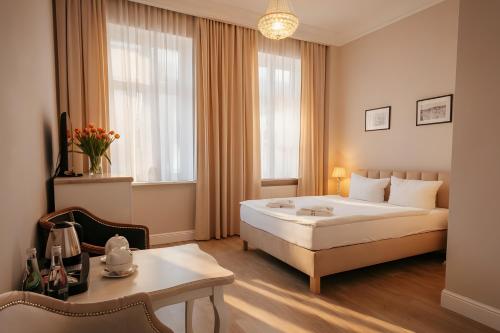 a hotel room with a bed and a table at Dwie Wieże in Międzyzdroje
