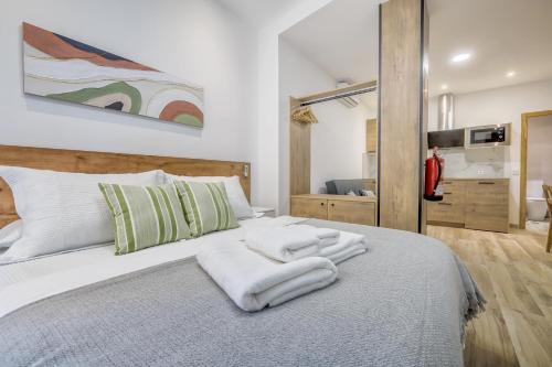 a bedroom with a bed with towels on it at Apartamentos Toril in Córdoba
