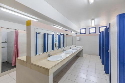 a bathroom with three sinks and a row of mirrors at HI Ovar - Pousada de Juventude in Ovar