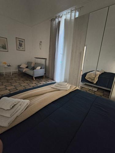 a bedroom with a bed with a mirror and a couch at IN CENTRO apartments in Torre Maggiore