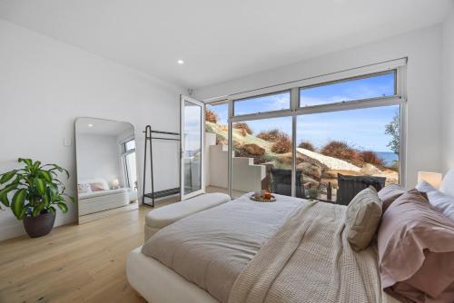 a bedroom with a large bed and a large window at Sunset Hideaway in Marino in Marino