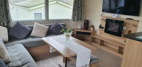 a living room with a couch and a table at Rockley Park, Poole, 3 Bedroom Family Retreat in Poole in Poole