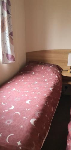 a bedroom with a bed with a pink blanket at Rockley Park, Poole, 3 Bedroom Family Retreat in Poole in Poole