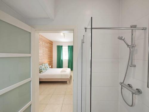 a bathroom with a walk in shower and a bedroom at Hilltop Retreat in Kalkara
