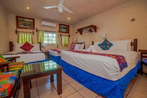 a hotel room with two beds and a couch at Hotel Sol Caribe in Isla Mujeres