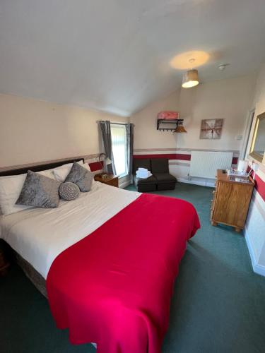 a bedroom with a large bed with a red blanket at The Fernroyd in Blackpool