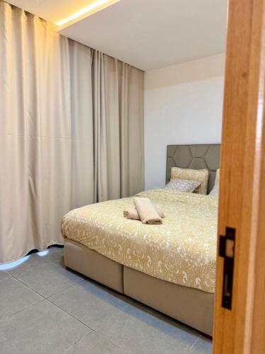 a bedroom with a bed and a window with curtains at SOHO Rooftop 360 Sunset Edition in Essaouira