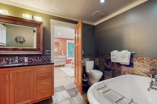 a bathroom with a tub and a toilet and a sink at Shore Thing Retreat in Eastsound