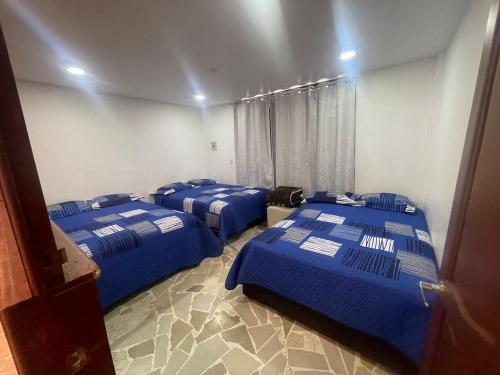 a room with three blue beds in it at Departamento MG in Puebla