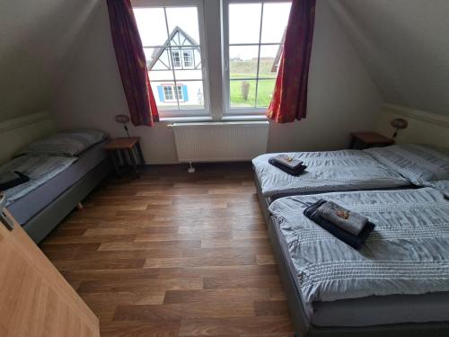 two beds in a small room with two windows at Haus am Golfplatz Cochem Mosel in Ediger-Eller