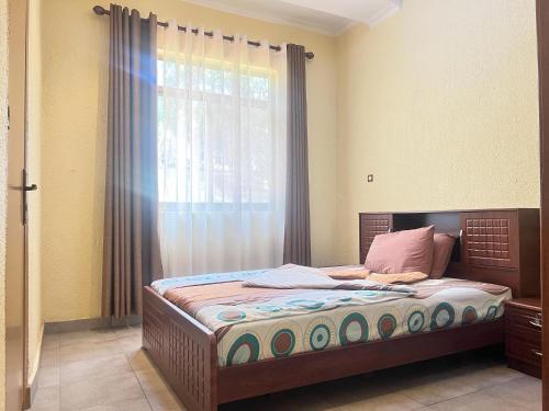 a bedroom with a large bed with a window at Centenary Gardens BnB in Kigali
