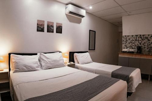 a hotel room with two beds and a tv at Urban Studio in Blumenau