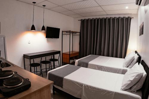 a hotel room with two beds and a table at Urban Studio in Blumenau