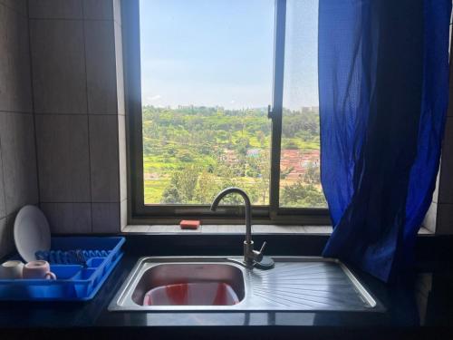 a kitchen sink with a window with a view at Centenary Gardens BnB in Kigali