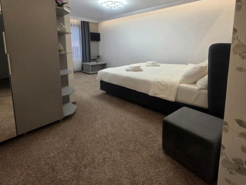 a bedroom with a bed and a stool in it at Hillcrest Panorama Valea Prahovei in Poiana Comarnic
