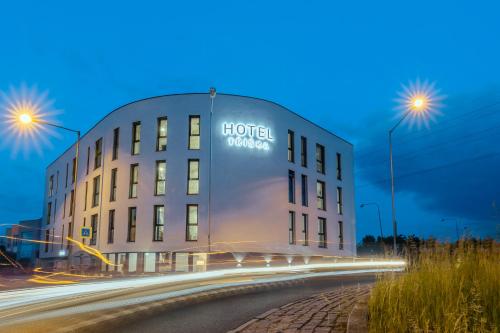 a hotel building with a sign on it at night at Hotel Tříška in Brandýs nad Labem