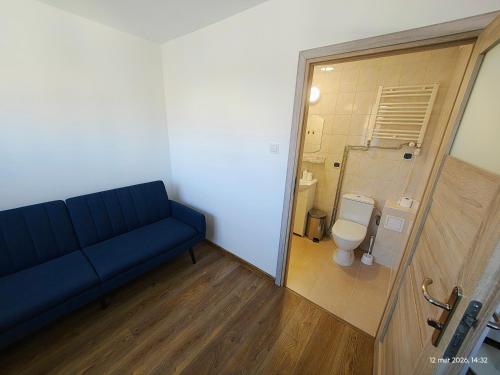 a blue couch in a bathroom with a toilet at Gryfhaus - Pokój Bosmański, kameralny, 22 m2, parking, Wi-Fi, blisko morza, wysoka ocena 9,9 in Międzyzdroje