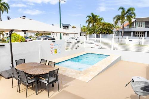 a patio with a table and chairs and a pool at AQUA Casa A-8 - Vibrant & FUN 3 BR House with Pool in Dorado