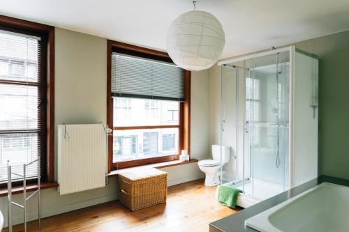 La salle de bains est pourvue d'une douche, de toilettes et de fenêtres. dans l'établissement Spacious Holiday Home, à Bruges