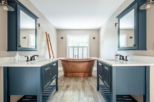 ein Badezimmer mit zwei Waschbecken und einer Badewanne in der Unterkunft Dock Square House in Kennebunkport