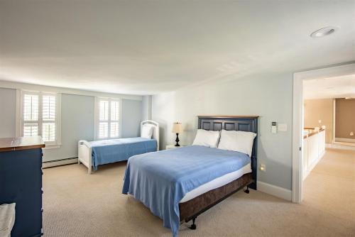ein Schlafzimmer mit zwei Betten mit blauer Bettwäsche in der Unterkunft Dock Square House in Kennebunkport