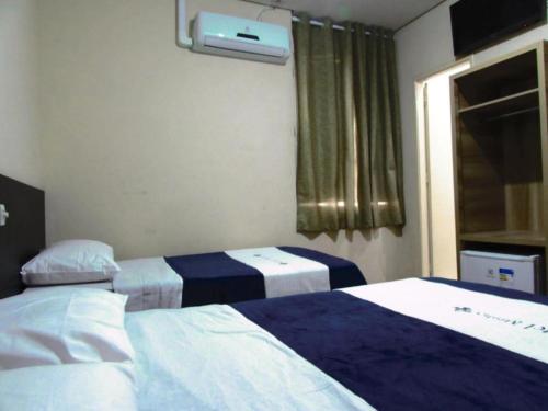 a hotel room with two beds and a window at Hotel Minho SP - Melhor Opção do Centro - Café da Manhã Incluso - Perto do Metrô, 25 de Março e Brás - 10 Min do Allianz Parque, 11 Min do Expo Center Norte e 9 Min do Distrito Anhembi in São Paulo