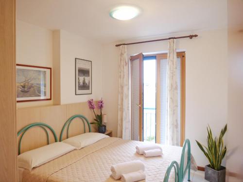 a bedroom with a bed and a window at Mareblu Apartments Grado in Grado