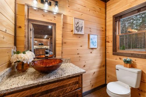 a log cabin bathroom with a sink and a toilet at 249 Ranger Station in Morganton