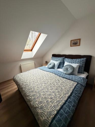 a bedroom with a bed with blue and gray pillows at Penzion Amfik in Mikulov