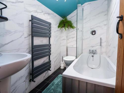 a bathroom with a tub and a sink and a toilet at The Green in Ripon