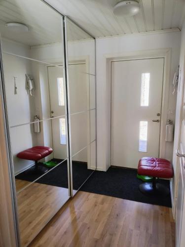 a dressing room with mirrors and two red chairs at Lägenhet Bolum 7 in Broddetorp