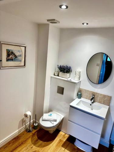 a bathroom with a white toilet and a sink at Central Taunton Townhouse in Taunton