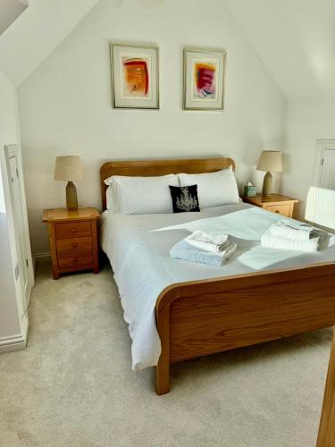 a bedroom with a large bed with two towels on it at Central Taunton Townhouse in Taunton