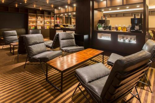 a waiting room with chairs and a table and a bar at Royal Park Hotel Takamatsu in Takamatsu