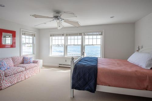 a bedroom with a bed and a couch and windows at Mother`s Beach House in Kennebunk