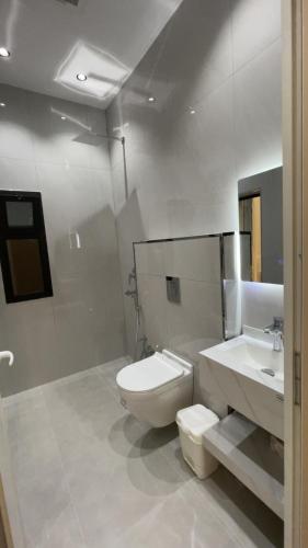 a white bathroom with a toilet and a sink at top one in Taif