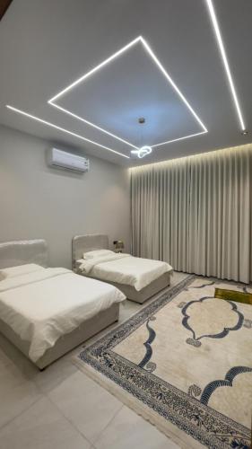 a room with two beds and a rug on the floor at top one in Taif