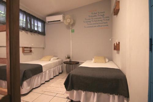 a room with two beds and a sign on the wall at La Bicicleta Hostal in Managua