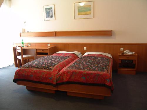 a hotel room with two beds and a desk and a desk at Hotel Altes Gasthaus Düsterbeck in Emsdetten