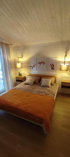 a bedroom with a large bed with orange sheets at Садиба Пташка in Krivopolʼye