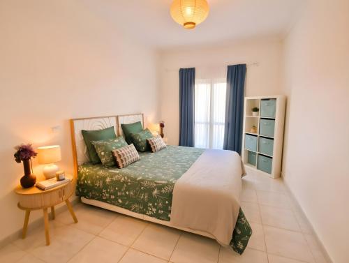 a bedroom with a bed and a table and a window at Apartamento Oásis Parque 2 in Portimão